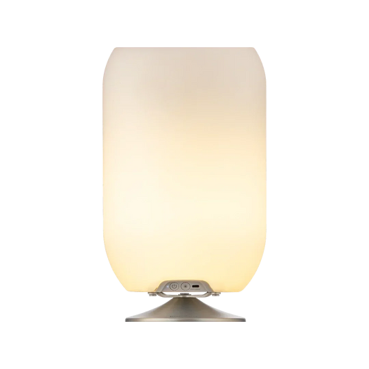 Lámpara con parlante Bluetooth y base plateada, luz cálida, diseño moderno para interiores.